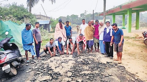 Protesting villagers near the newly-laid damaged road.
