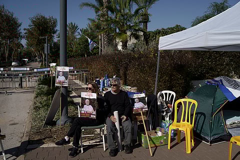 Relatives and friends of hostages sit on a camp set up outside the private residence of the Israeli Prime Minister Benjamin Netanyahu