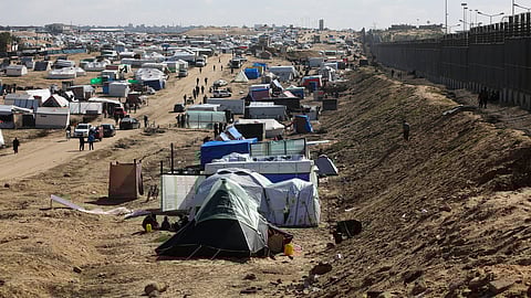 Palestinians displaced by the Israel air and ground offensive on the Gaza Striptake shelter near the border fence with Egypt in Rafah, Wednesday, Jan. 24, 2024. 