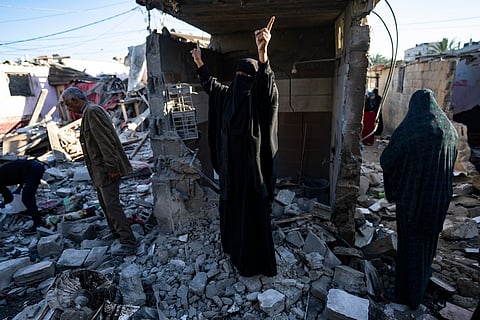 Palestinians look at the destruction after an Israeli strike in Rafah, southern Gaza Strip, Thursday, Jan. 18, 2024.