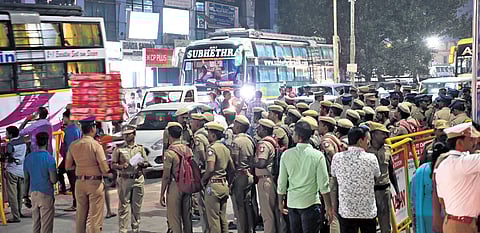 Policemen stand guard near the omnibus stand at Koyambedu on Wednesday night. 
