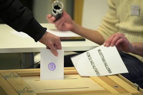 A woman casts her ballot at a polling station during presidential election in Helsinki, Finland, Sunday, Jan. 28, 2024.