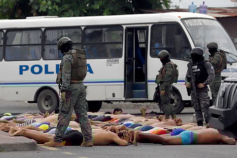 Police keep watch over arrested men who attempted to take over a hospital in Guayas, Ecuador, on January 21, 2024.
