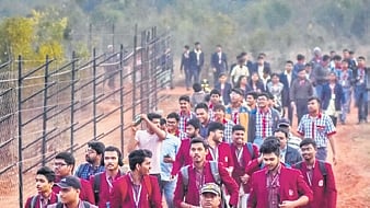 Students walk to a temporary deer enclosure during the night trail.