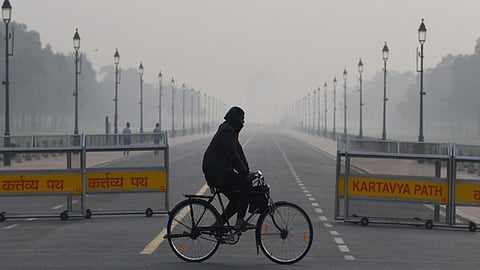A man cycles along the Kartvya Path area of the national capital amid poor air quality.