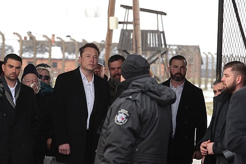 Tesla and SpaceX's CEO Elon Musk, centre, walks during his visit to the site of the Auschwitz-Birkenau Nazi German death camp in Poland