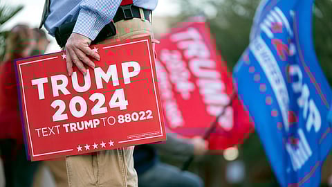 A man holds a sign for Republican presidential candidate former President Donald Trump before a campaign event for his rival former UN Ambassador Nikki Haley at The North Charleston Coliseum, Wednesday, Jan. 24, 2024, in North Charleston, S.C.
