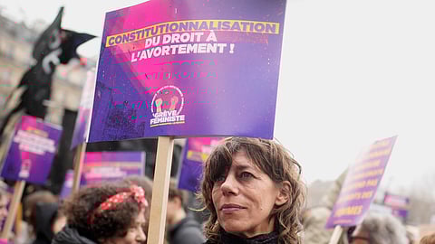 A woman demonstrates with a poster reading "Abortion in the Constitution" as part of the International Women's Day, Wednesday, March 8, 2023 in Paris.