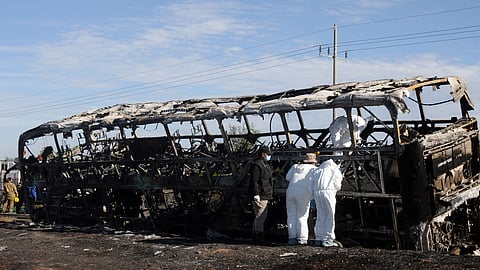 Agents of the local Attorney check a burnt passenger bus after it crashed with a truck at the Mazatlan-Culiacan highwat in the community of La Cruz, Sinaloa state, Mexico on January 30, 2024.