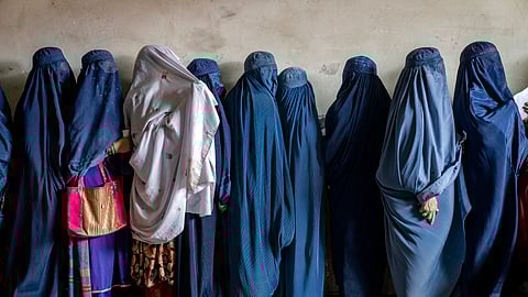 Afghan women wait to receive food rations distributed by a humanitarian aid group, in Kabul, Afghanistan, on May 23, 2023.