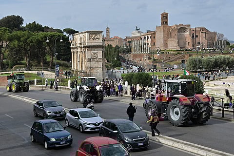 Farmers drive their tractors in front of Ancient Foro Romano, as part of an action by farmers to pressure the government to improve their working conditions, in central Rome on February 9, 2024.