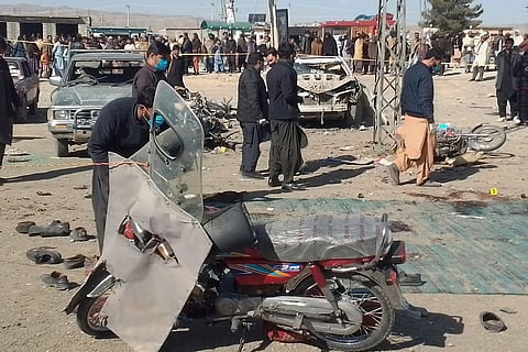 Security officials examine the scene of a bomb blast in Khanozai, Pashin, a district of Pakistan's Balochistan province, Wednesday, Feb. 7, 2024.