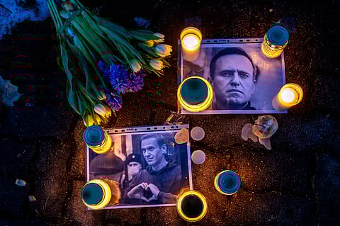 Photos of Russian opposition leader Alexei Navalny, with flowers and candles are laid on a ground in front of the Russian embassy. 