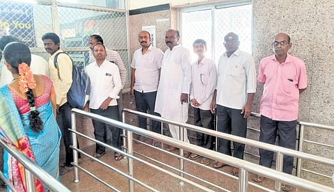 Residents wait in queues to buy tickets at the Nekkonda Railway Station in Warangal district. 