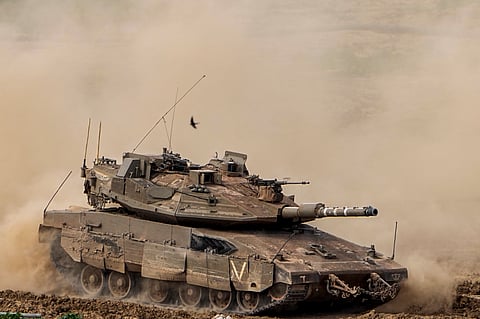 Israeli soldiers drive a tank inside Gaza Strip, as seen from southern Israel, Tuesday, Feb. 13, 2024. 