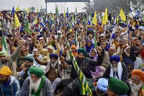 Farmers listen to a leader at the Punjab-Haryana Shambhu border during their 'Delhi Chalo' protest, near Patiala district.