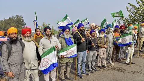 Farmers hold flags during their ongoing protest over various demands, including a legal guarantee of minimum support price (MSP) for crops, at the Punjab-Haryana Shambhu Border, in Patiala district, on Tuesday, Feb. 20, 2024.