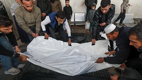 Palestinians mourn over the body of a victim following Israeli bombardment on Rafah in the southern Gaza Strip, at al-Najar hospital on February 16, 2024