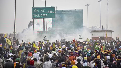 Farmers move away after police fired teargas shells to disperse them during their 'Delhi Chalo' march at the Punjab-Haryana Shambhu border, near Patiala, Tuesday, Feb. 13, 2024.