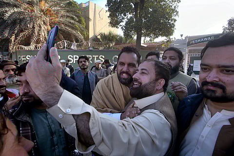 Meena Khan Afridi, center, an independent candidate backed by Pakistan's former Prime Minister Imran's party poses for selfie with supporters following his victory in the parliamentary elections, in Peshawar, Pakistan, Friday, Feb. 9, 2024.