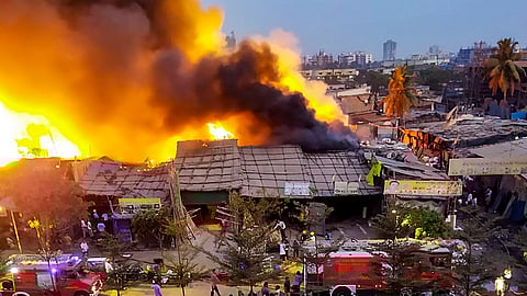 Firefighters at the spot after a fire broke out in a slum, at Bhayandar in Thane district.