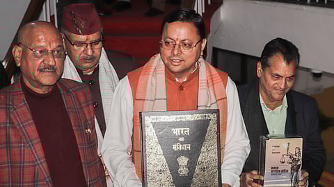 Uttarakhand Chief Minister Pushkar Singh Dhami, along with others holds a copy of the Constitution of India, at Vidhan Sabha Bhawan, in Dehradun, Tuesday, Feb. 6, 2024.