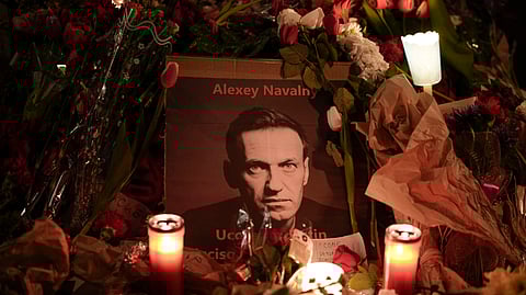 Flowers and candles are laid around a photo of Russian opposition leader Alexei Navalny during a rally to commemorate him, at Rome's Piazza del Campidoglio city council square, Monday, Feb. 19, 2024