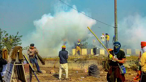 Farmers retaliate with water after police used tear gas to disperse them during their 'Delhi Chalo' march, at the Punjab-Haryana Shambhu border in Patiala