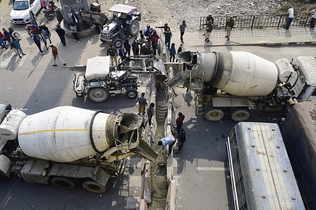 Workers use concrete mix to create a barricade at the Ghazipur border on Monday.