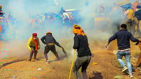 Farmers spray warer police used tear gas to disperse them during their 'Delhi Chalo' march, at the Punjab-Haryana Shambhu border in Patiala district, on Feb. 14, 2024. 