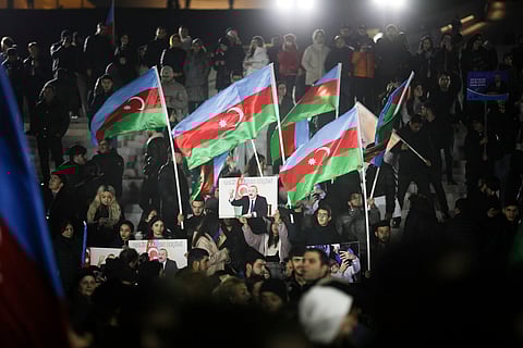 People wave national flags celebrating Azerbaijan's President Ilhan Aliyev's victory in the presidential election in Baku, Azerbaijan.