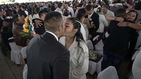 Couples kiss during a collective wedding celebration at the esplanade of the Municipal Palace of Nezahualcoyotl, just outside Mexico City, on February 14, 2024