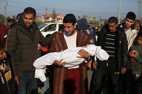 Palestinian Abdul Rahman Sharif holds the body of his four-year-old son Abdul Rahman Muamm, killed in the Israeli bombardment of the Gaza Strip, during his funeral in Khan Younis.
