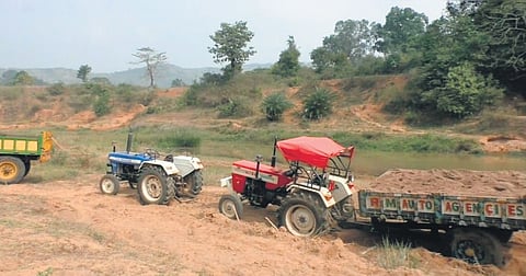 Tractors loaded with sand parked along Ram Nadi river in Gajapati district.