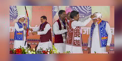 Prime Minister Narendra Modi being presented a a bow and arrow and a headgear during the 'Janjatiya Sammelan' in Jhabua.