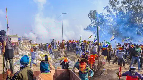 Farmers look for cover after police fired tear gas at them during their 'Delhi Chalo' march, near the Punjab-Haryana Shambhu border, in Patiala district.