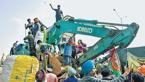Farmers with an excavator modified to shield the agitators from police rubber bullets, at the Punjab-Haryana Shambhu border in Patiala district on Tuesday, Feb 20, 2024