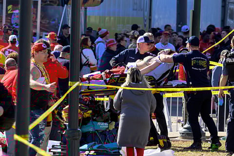A woman is taken to an ambulance after an incident following the Kansas City Chiefs NFL football Super Bowl celebration in Kansas City, Mo., Wednesday, Feb. 14, 2024. The Chiefs defeated the San Francisco 49ers Sunday in the Super Bowl 58.