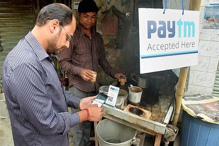 A person pays his bill at a tea stall using Paytm app at Balurghat in South Dinajpur 
