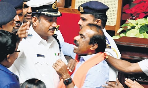 BJP MLC V Ravikumar argues with marshals, as he protests against a Congress member addressing him in the singular, during the Council session at Vidhana Soudha in Bengaluru on Wednesday