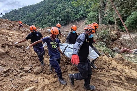 In this Feb. 9, 2024 handout photo from Municipality of Monkayo, rescuers carry a body they recovered at the landslide-hit village of Maco in Davao de Oro province, southern Philippines.