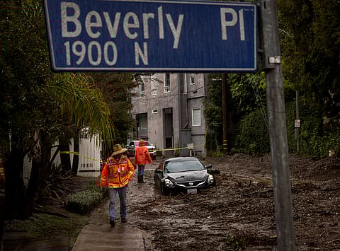 Workers survey a mudslide in the Beverly Crest area of Los Angeles on Tuesday, Feb. 6, 2024.