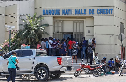 People line up outside a bank that had been closed for several days due to the violence, in Port-au-Prince, Haiti, Wednesday, March 13, 2024.