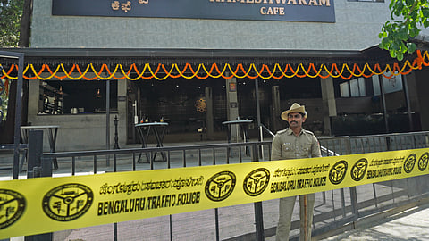 A Police personnel stand guard near the site of a bomb blast at Rameshwaram Cafe. 
