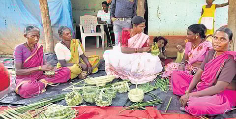 Women from the Kolam tribe learn how to weave baskets using cattail grass through DRDA project officer K Vijayalakshmi at Kolamguda village of Nirmal district.