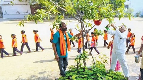 Jakula Venkatesh puts up an earthen pot at a school in the erstwhile Adilabad district
