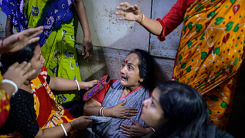 Family members of a victim in a fire that broke out at a commercial complex react in a hospital in Dhaka, Bangladesh, Friday.