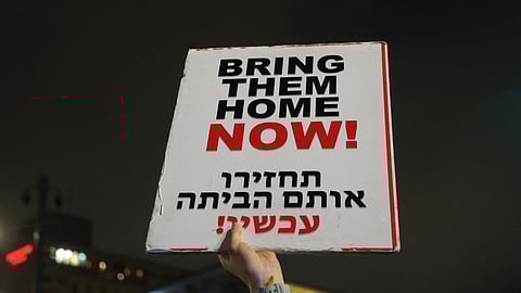 A protester holds a placard calling for action to obtain the freedom of the Israeli hostages held in Gaza during a demonstration in front of the Israeli prime minister's residence in Jerusalem on March 2, 2024.