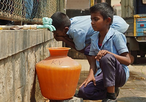 A schoolboy seen waiting for water to drink due to a shortage of drinking water in Bengaluru 