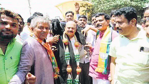 Residents welcome former CM Basavaraj Bommai to Singatalur village by placing a goat on his shoulders 